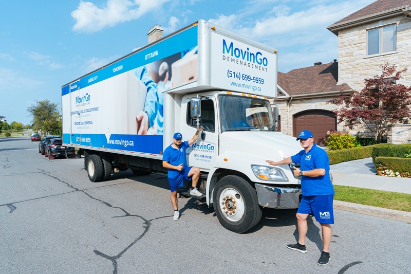 Professional MovinGo movers beside their truck in Greater Montreal