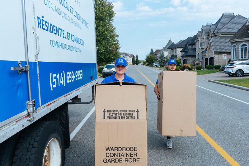MovinGo movers carrying wardrobe boxes during a residential move